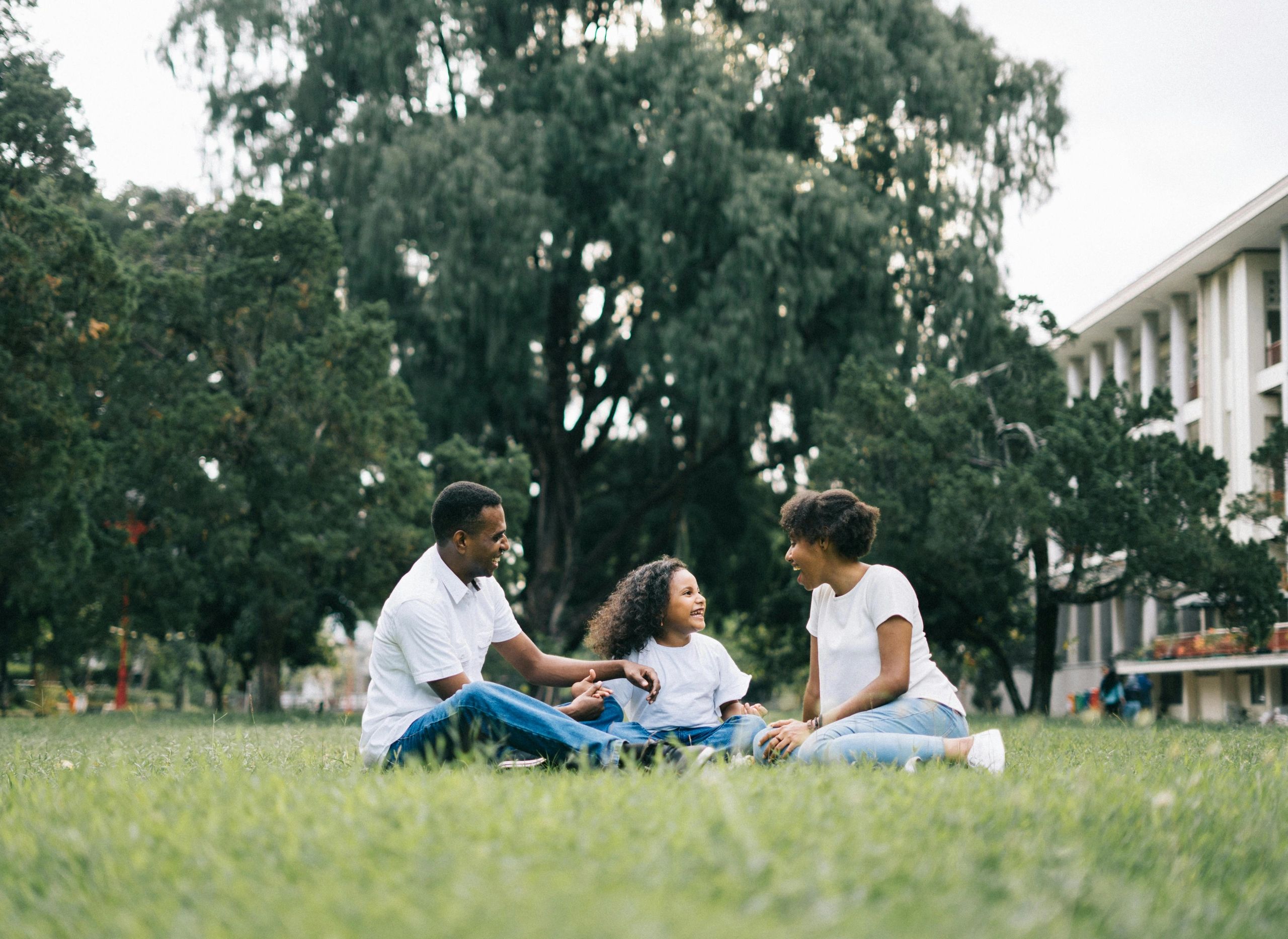 Happy family sitting on grass in park